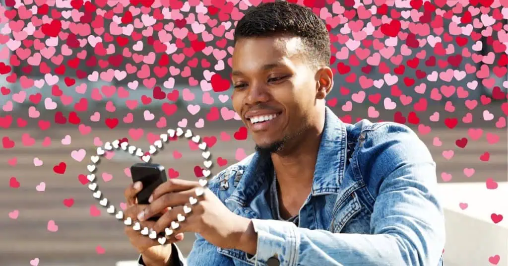 man looking at phone smiling with hearts in the background